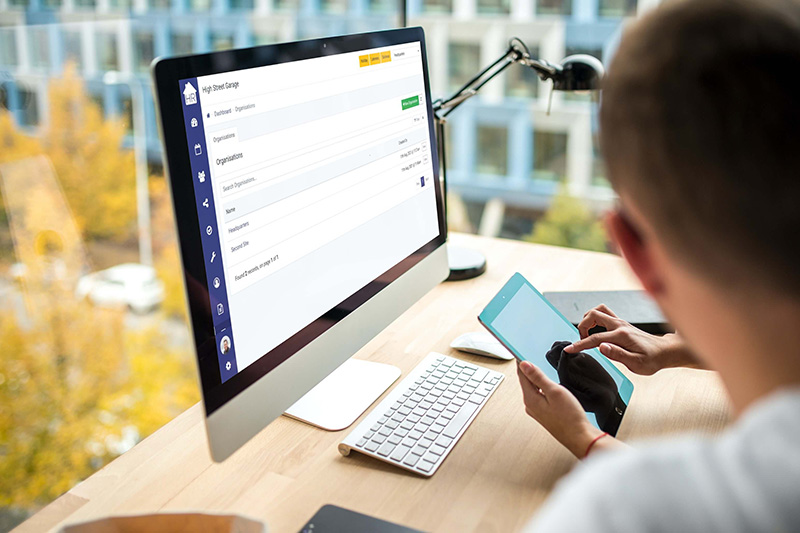 Someone using a tablet in front of an iMac